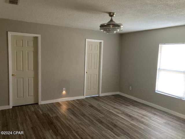 empty room with wood-type flooring and a textured ceiling