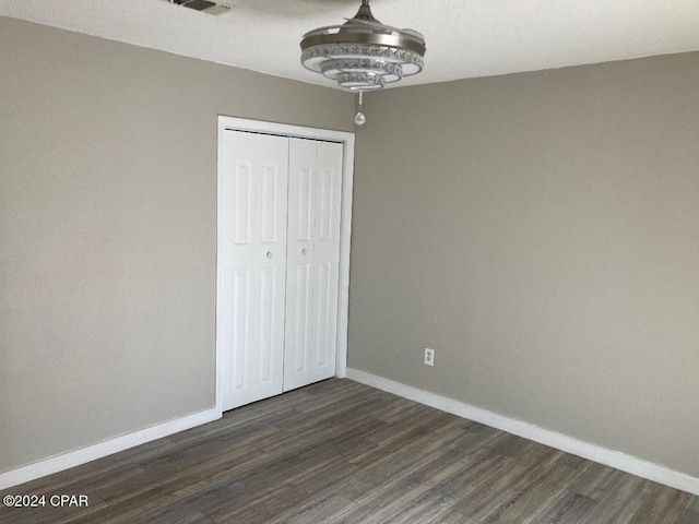 unfurnished bedroom featuring dark hardwood / wood-style floors and a closet