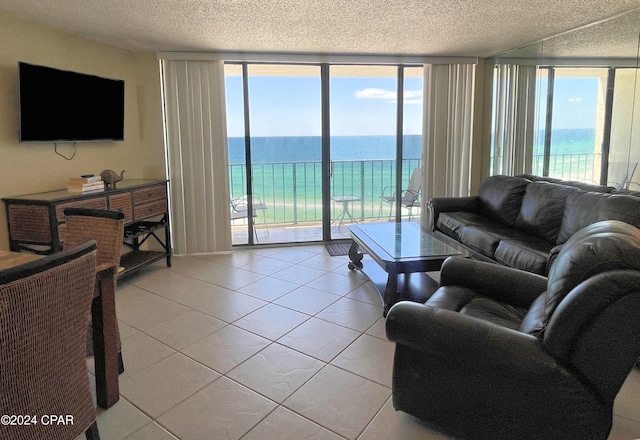 living room with expansive windows, a water view, and a wealth of natural light