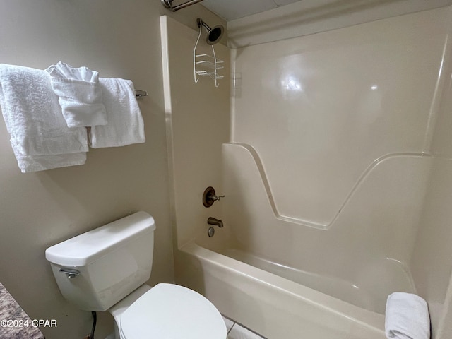 bathroom with bathing tub / shower combination, tile patterned flooring, and toilet