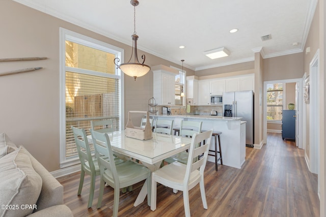 dining room featuring crown molding and dark wood-type flooring