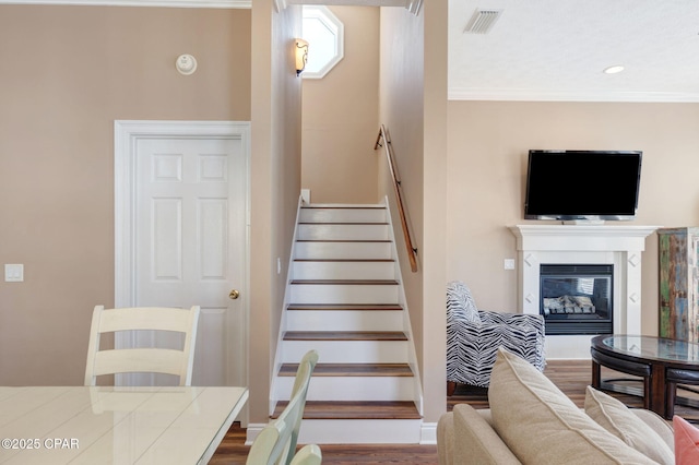 stairway featuring hardwood / wood-style flooring and ornamental molding