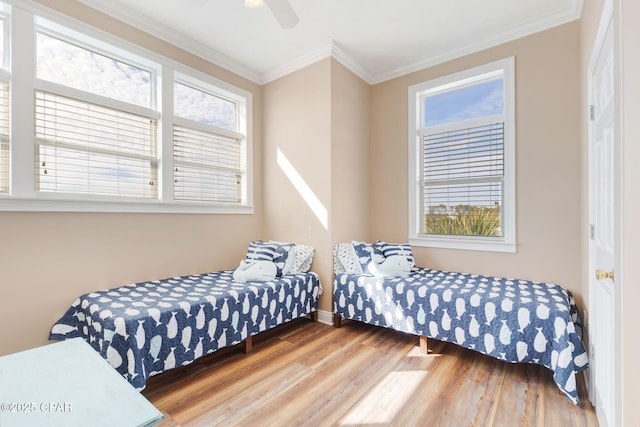 bedroom with hardwood / wood-style flooring, crown molding, and ceiling fan