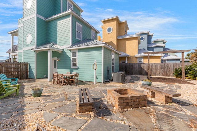 back of house featuring a patio, central AC unit, and a fire pit