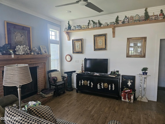 living room with a brick fireplace, crown molding, dark hardwood / wood-style flooring, and ceiling fan