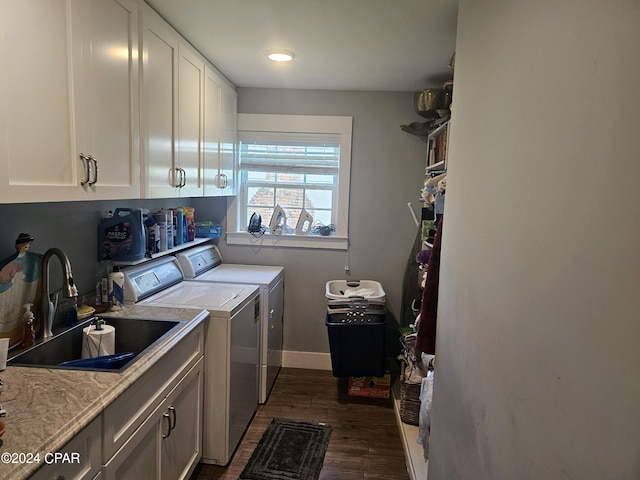 clothes washing area featuring cabinets, dark hardwood / wood-style floors, separate washer and dryer, and sink