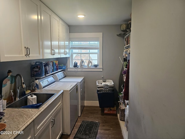 clothes washing area featuring dark wood-type flooring, washer and dryer, sink, and cabinets