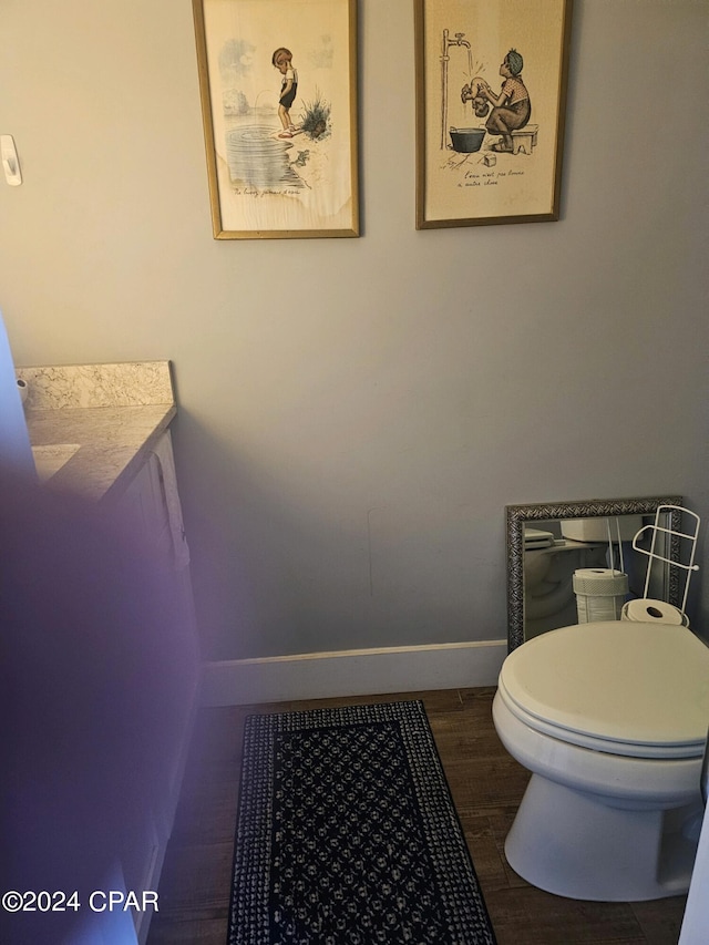 bathroom featuring hardwood / wood-style flooring and toilet