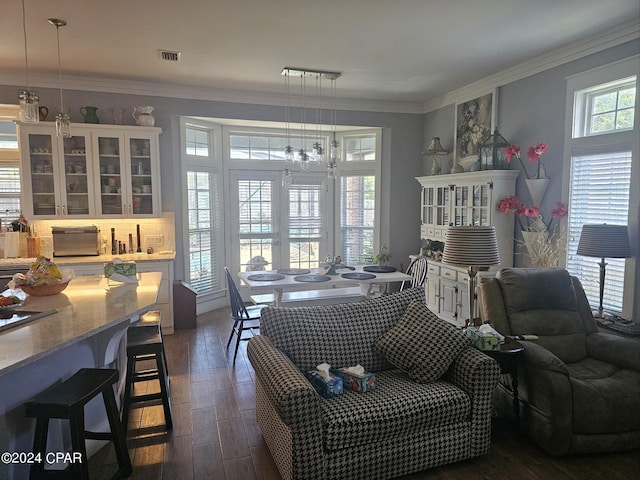 living room featuring a chandelier, dark hardwood / wood-style floors, and crown molding