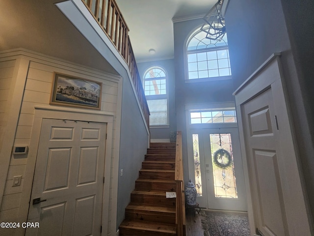 foyer entrance with a high ceiling and crown molding