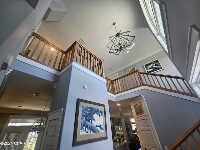 stairway with a chandelier and a high ceiling