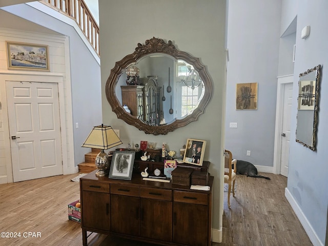 interior space with light hardwood / wood-style flooring and a high ceiling