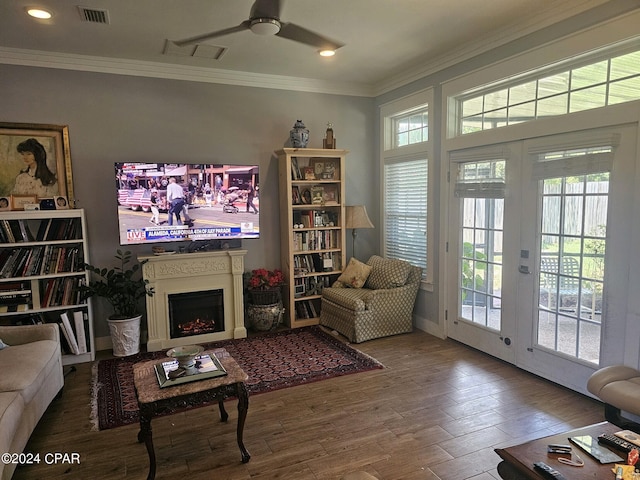 living room with a healthy amount of sunlight, crown molding, hardwood / wood-style floors, and ceiling fan