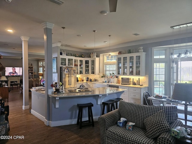 kitchen with dark hardwood / wood-style floors, white cabinetry, hanging light fixtures, a kitchen island, and stainless steel appliances