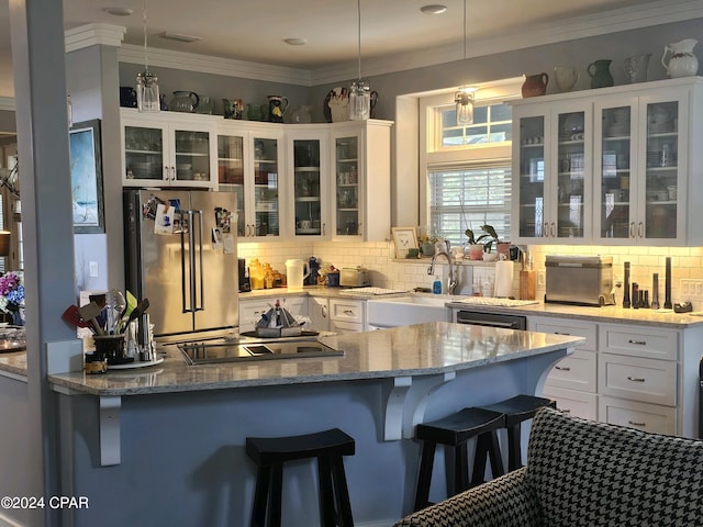 kitchen featuring decorative light fixtures, white cabinetry, a breakfast bar area, light stone countertops, and high end refrigerator