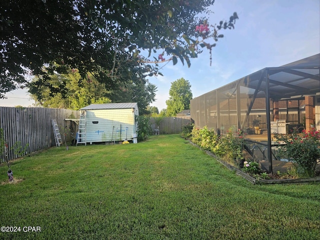 view of yard with glass enclosure and a storage shed