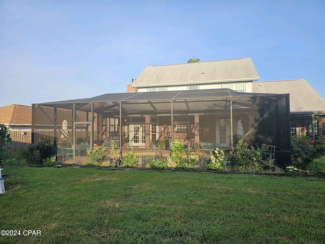 back of property featuring glass enclosure and a yard