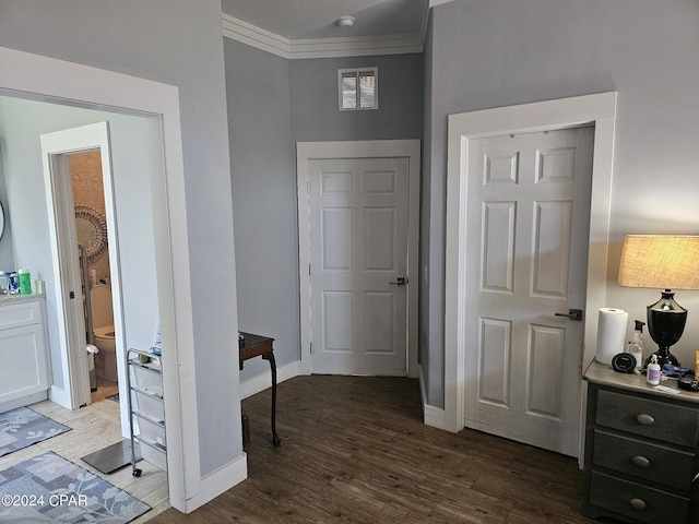 foyer featuring ornamental molding and hardwood / wood-style floors