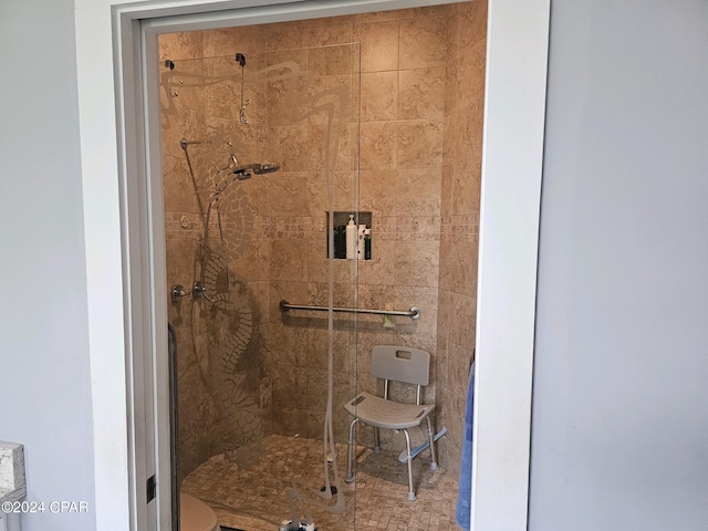 bathroom with a tile shower and toilet