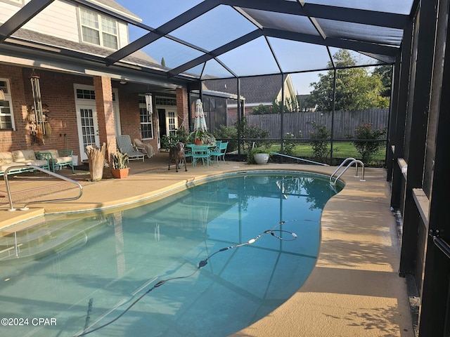 view of pool featuring glass enclosure, ceiling fan, and a patio