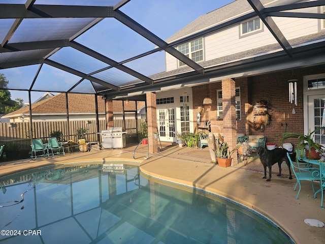 view of swimming pool with french doors, area for grilling, a patio, and a lanai