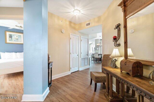 hallway with wood-type flooring and a chandelier