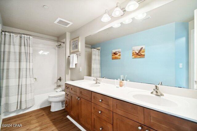 full bathroom with vanity, toilet, wood-type flooring, and shower / bath combo