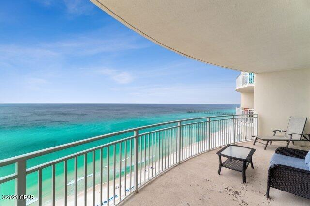 balcony featuring a beach view and a water view