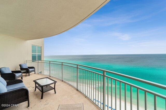 balcony with a water view and a view of the beach