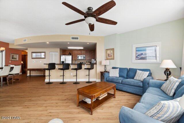 living room featuring ceiling fan and light hardwood / wood-style flooring