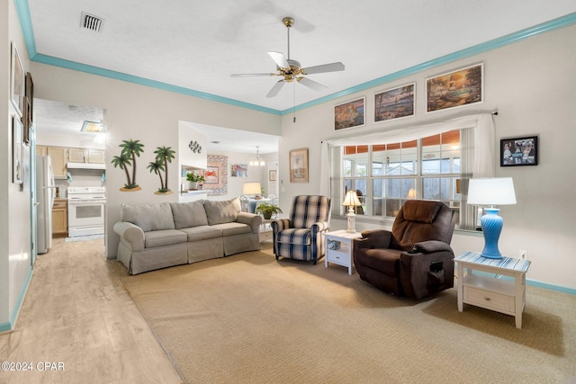 living area featuring a ceiling fan, baseboards, light wood-style floors, visible vents, and crown molding