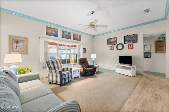 living room featuring light wood-type flooring, visible vents, baseboards, and a ceiling fan