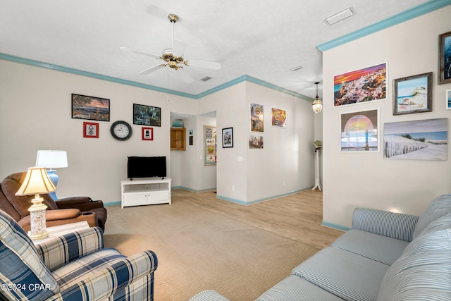 living area with light carpet, a ceiling fan, visible vents, and crown molding