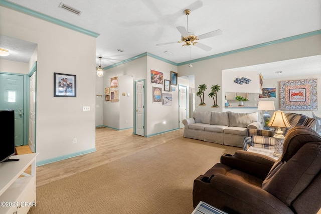 living area featuring light carpet, baseboards, visible vents, a ceiling fan, and crown molding