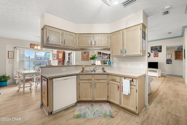 kitchen with a sink, visible vents, light countertops, dishwasher, and light wood finished floors