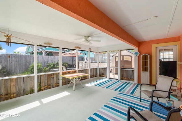 unfurnished sunroom with ceiling fan