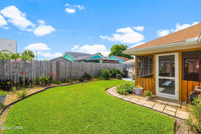 view of yard featuring fence private yard and a sunroom