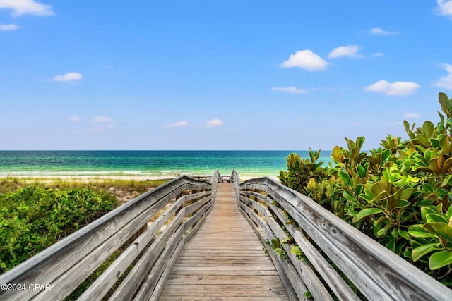 view of property's community featuring a water view and a beach view