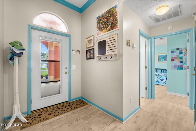 entrance foyer with visible vents, light wood-style flooring, and baseboards