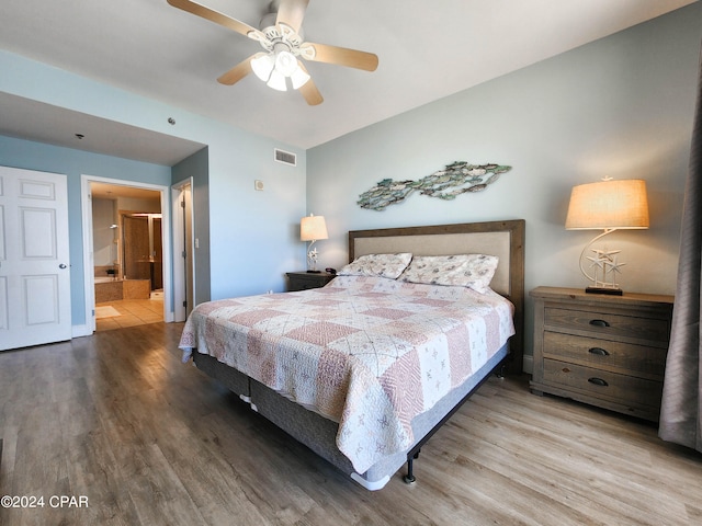 bedroom featuring connected bathroom, hardwood / wood-style floors, and ceiling fan