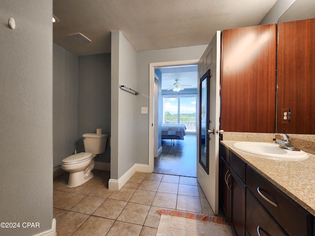 bathroom featuring tile patterned floors, vanity, a textured ceiling, and toilet