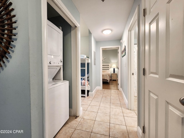 hall featuring light hardwood / wood-style floors and stacked washing maching and dryer