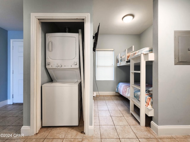 tiled bedroom featuring stacked washer and clothes dryer and electric panel