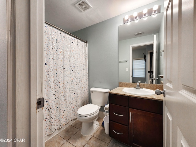 bathroom featuring vanity, toilet, and tile patterned flooring