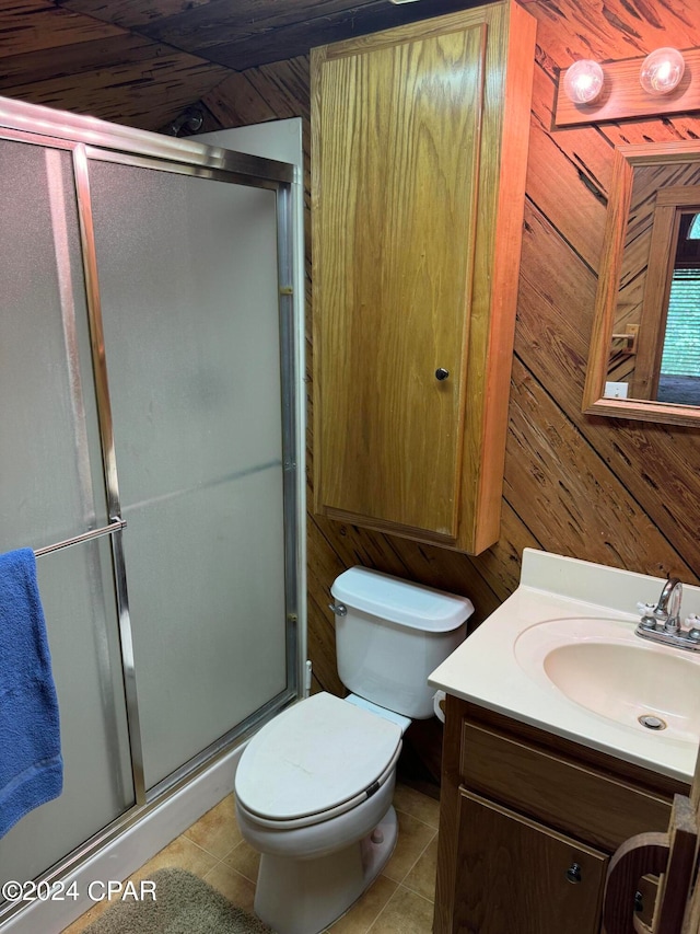 bathroom featuring vanity, tile patterned floors, wooden walls, an enclosed shower, and toilet