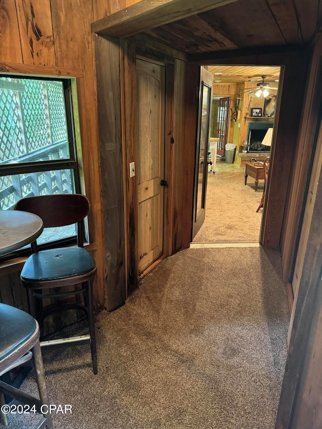 corridor featuring wood walls and carpet flooring