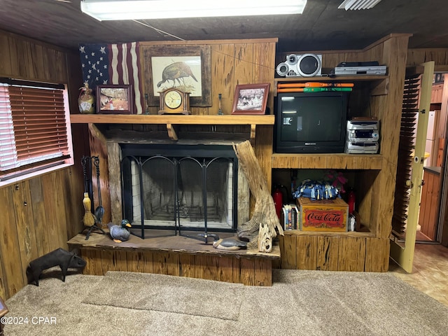 carpeted living room featuring wood walls