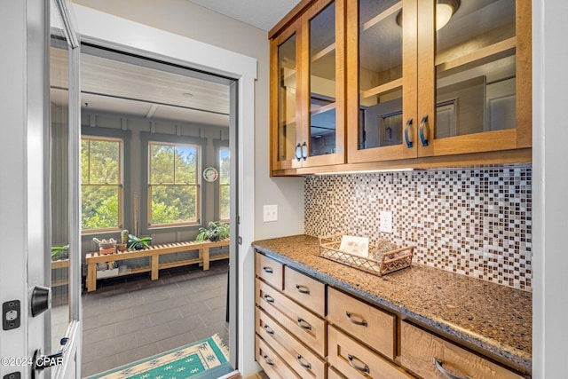 kitchen with tile patterned flooring, decorative backsplash, and stone countertops