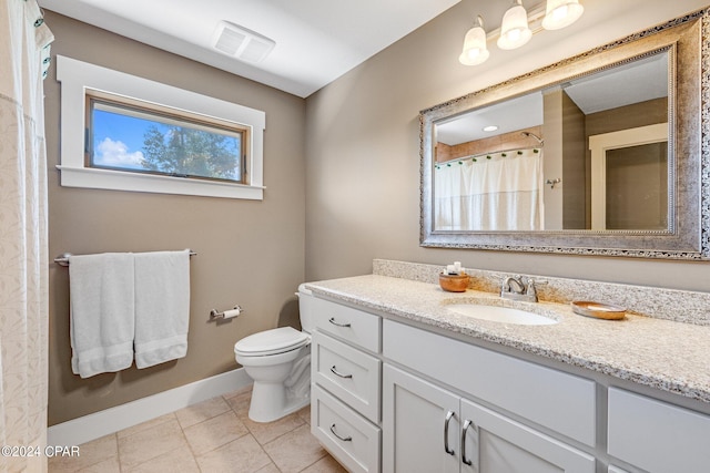 bathroom featuring tile patterned flooring, toilet, and vanity