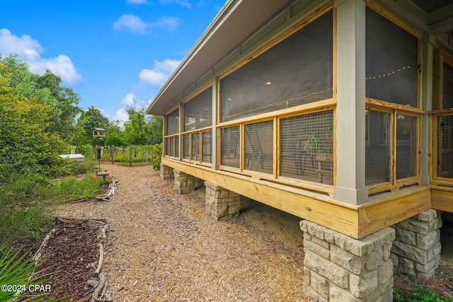 view of property exterior with a sunroom